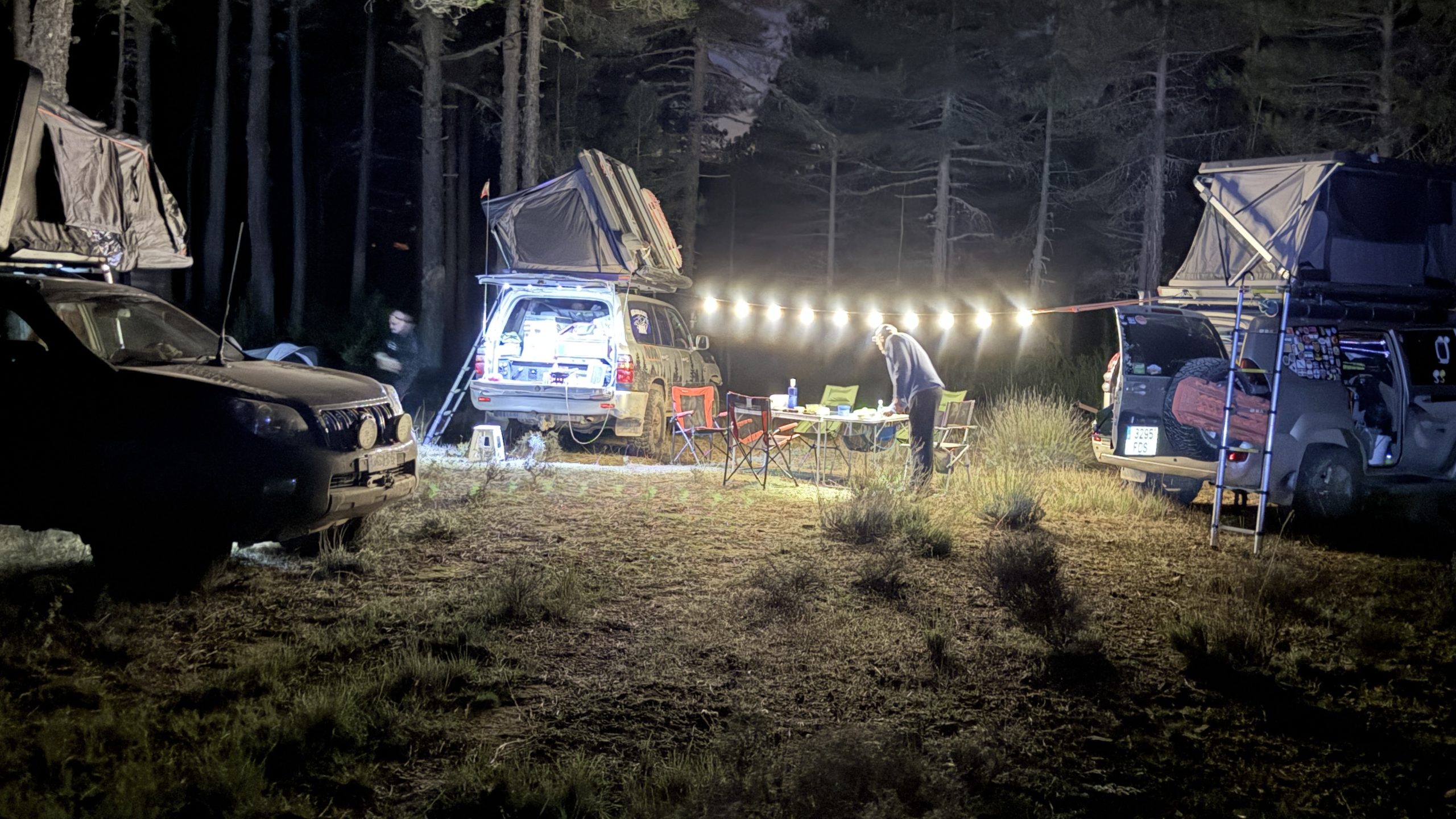 Campamento nocturno de los tres vehículos en el bosque